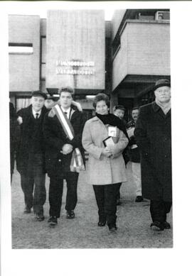 Sola Sierra caminando acompañada de un grupo de hombres