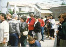 Grupo de personas reunidas frente a una construcción.
